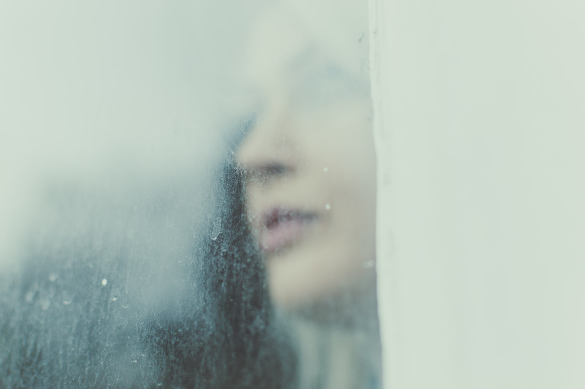 woman looking through a foggy window